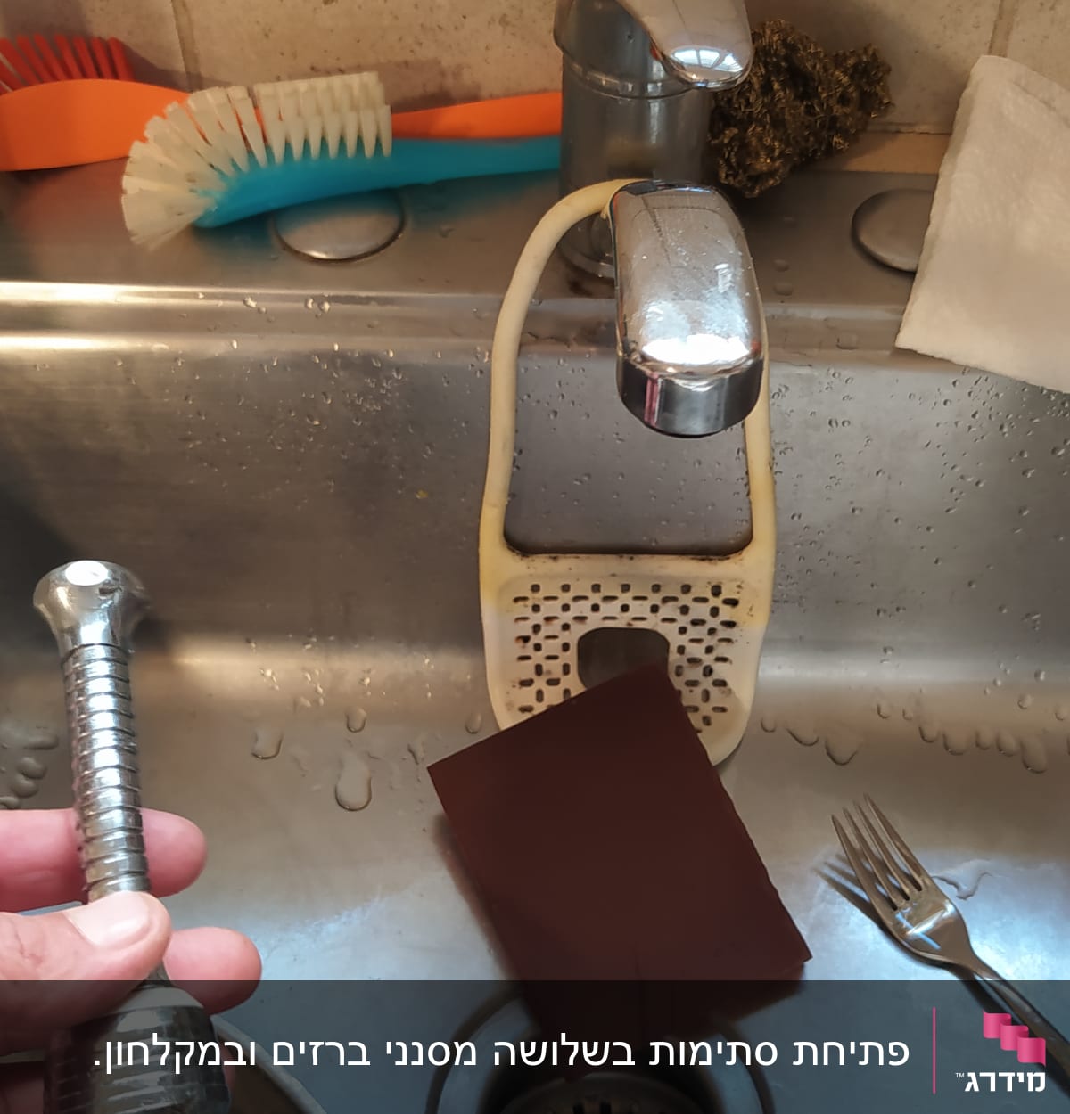 יד מחזיקה חלק ברז בכיור מטבח